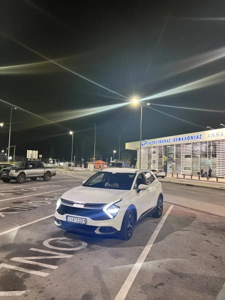 White Kia Sportage automatic 4x4 rental car outside Kefalonia Airport, three-quarter view